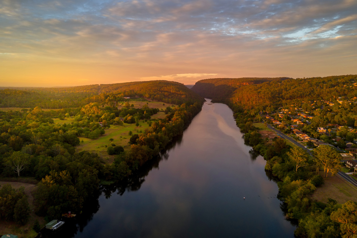 aerial view of river with sun rising over horizon